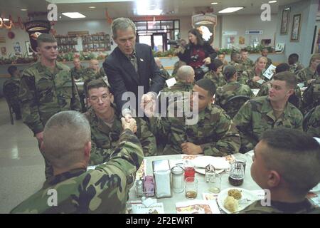 Präsident George W. Bush schüttelt sich die Hände mit Soldaten während eines Erntedankmahls in Fort Campbell, Kentucky. Stockfoto