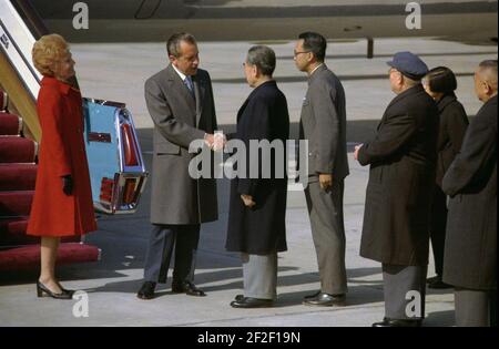 Präsident Richard Nixon und Premier Chou en-Lai schütteln die Hände bei der Ankunft der Nixons in Peking, China. Stockfoto