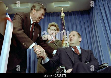 Präsident Ronald Reagan und Nancy Reagan mit James Brady bei einer Zeremonie zur Wiedereröffnung des Presseraums des Weißen Hauses. Stockfoto