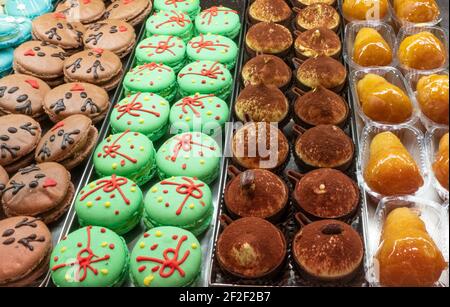 Bunte Macarons und leckeres Gebäck im Fenster der Konditorei Stockfoto