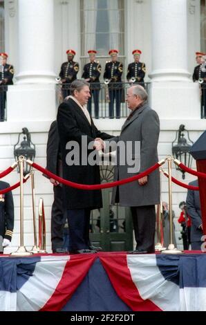 Präsident Ronald Reagan und der sowjetische Generalsekretär Michail Gorbatschow schüttelten sich bei der Ankunftszeremonie auf dem südlichen Rasen des Weißen Hauses die Hände. Stockfoto