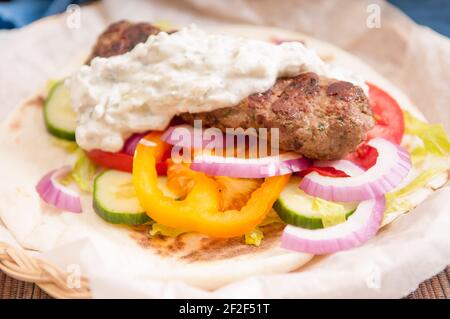 Lecker Fladenbrot wrap koobideh, iranische Spieß mit frischem Gemüse und Tzatziki Sauce Stockfoto