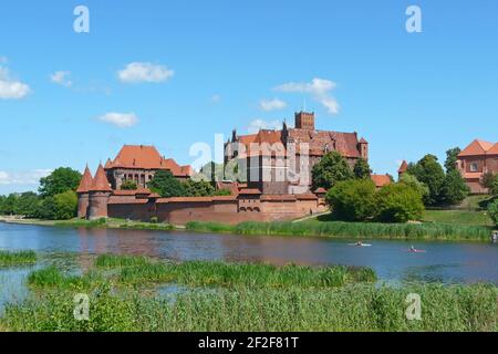 Die Marienburg in Malbork vom Westufer der Nogat in Polen, die größte Backsteinburg der Welt Stockfoto