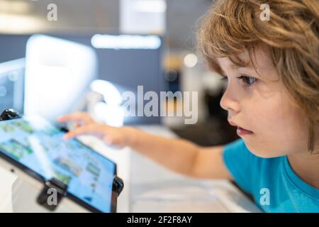 Kind im Computerladen. Digitale Geräte und Elektronik. Verkauf von Laptops. Stockfoto