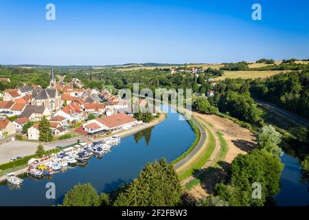 Luftaufnahme auf dem Radweg entlang des Flusses. Boote in Hafen und Stadt mit Kirche auf dem gegenüberliegenden Ufer. Sommertag in der französischen Landschaft. Stockfoto