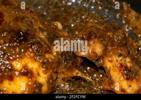 Kleine Stücke Hühnerfleisch werden mit Gewürzen geschmort. Nahaufnahme mit selektivem Fokus. Stockfoto