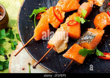Kebabs aus getrockneten und Lachs auf Holzspießen.gesalzene Lachsscheiben Stockfoto