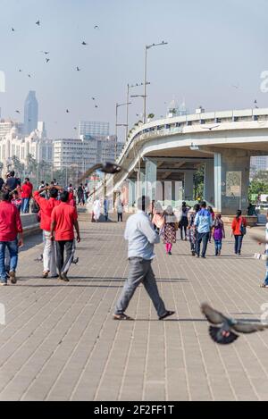 Promenade in Mumbai, Passanten und Schar von Tauben auf einer Autobrücke Stockfoto