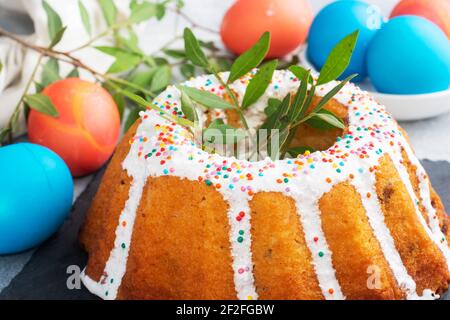 Osterkuchen in Puderzucker bemalte Eier auf dem Tisch Stockfoto