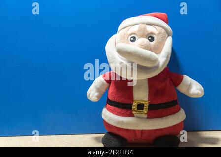 Weihnachtsmann Puppe. Blauer weihnachtlicher Hintergrund. Gründe für den Weihnachtstag. Party-Deko zum Jahresende. Katholisches Fest. Stockfoto