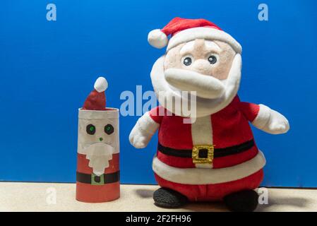 Weihnachtsmann Puppe. Blauer weihnachtlicher Hintergrund. Gründe für den Weihnachtstag. Party-Deko zum Jahresende. Katholisches Fest. Stockfoto