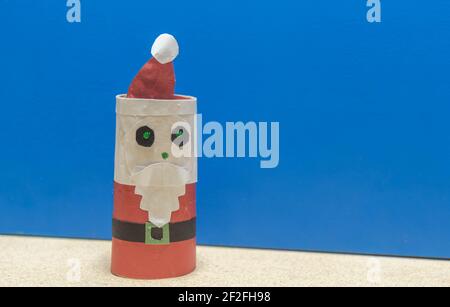 Weihnachtsmann Puppe. Blauer weihnachtlicher Hintergrund. Gründe für den Weihnachtstag. Party-Deko zum Jahresende. Katholisches Fest. Stockfoto