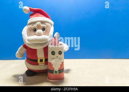 Weihnachtsmann Puppe. Blauer weihnachtlicher Hintergrund. Gründe für den Weihnachtstag. Party-Deko zum Jahresende. Katholisches Fest. Stockfoto