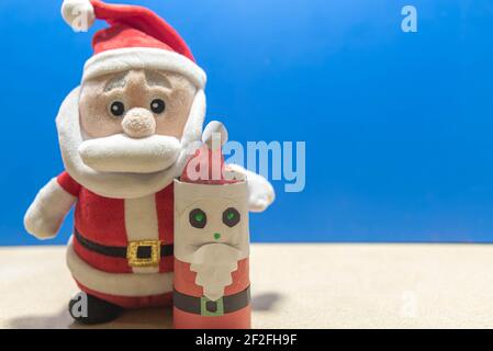 Weihnachtsmann Puppe. Blauer weihnachtlicher Hintergrund. Gründe für den Weihnachtstag. Party-Deko zum Jahresende. Katholisches Fest. Stockfoto