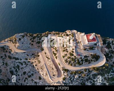 Formentor Cape Leuchtturm und kurvige Straße in Mallorca bei Sonnenuntergang Luftaufnahme - mit Kopierraum Stockfoto