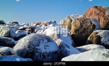 Haufen verschneite Felsen in den Winterbergen an einem sonnigen Wintertag mit blauem Himmel. Winterlandschaft Stockfoto