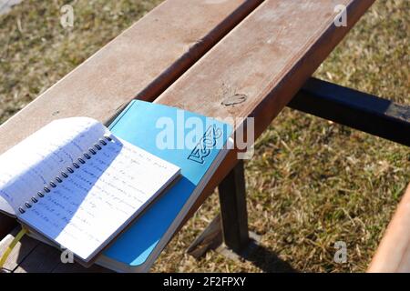 Notizbuch und Agenda auf Holzbank geöffnet Stockfoto
