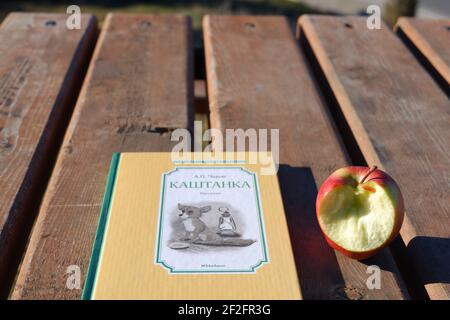 Russisches Buch 'Kashtanka' und Apple Outdoor auf Holztisch Stockfoto