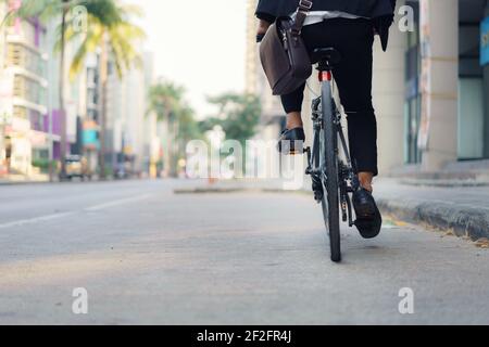 Nahaufnahme der Geschäftsmann fährt auf den Straßen der Stadt mit dem Fahrrad, um am Morgen zur Arbeit zu pendeln. Eco Transportkonzept. Stockfoto