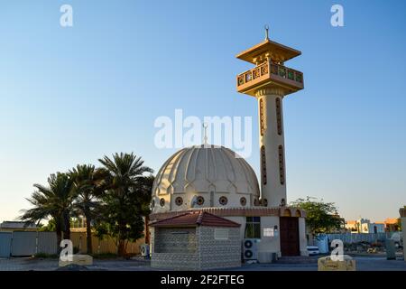 Eine kleine alte Moschee, umgeben von Dattelpalmen Stockfoto