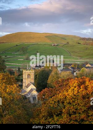 Der St. Wilfrid's Church ist unter den kräftigen Farben des Herbstes Laub sichtbar im malerischen Dorf Burnsall, Yorkshire Dales National Park. Stockfoto