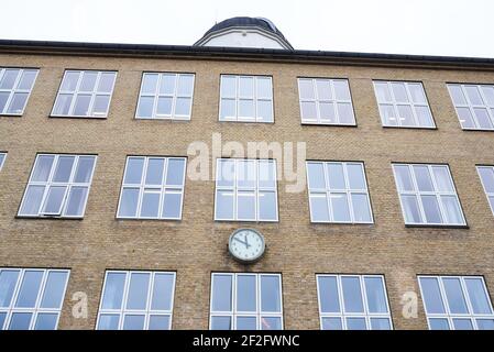 Schulgebäude mit einer großen Uhr auf dem Gebäude Stockfoto