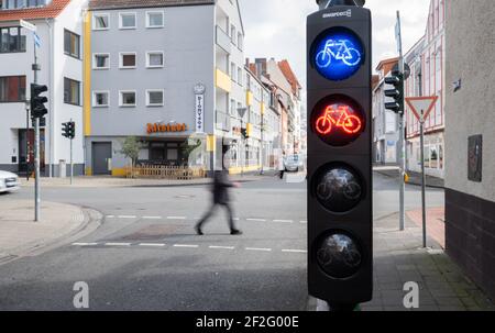 Hildesheim, Deutschland. März 2021, 12th. An einer Kreuzung leuchten eine blaue und eine rote Ampel für Radfahrer auf. Die Verwirrung unter den Radfahrern in Hildesheim ist groß: Kürzlich leuchtet auch an einer Kreuzung eine blaue Ampel auf - aber ohne Erklärung. Kaum jemand weiß, was das blaue Ampelsignal bedeuten soll. Laut Hildesheim soll die blaue Ampel darauf hinweisen, dass der Fahrradverkehr erkannt wurde und keine zusätzlichen Tasten betätigt werden müssen. Kredit: Julian Stratenschulte/dpa/Alamy Live Nachrichten Stockfoto