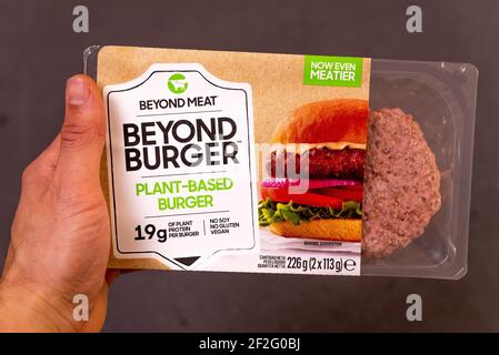 rom, italien - 10. märz 2021:Hand halten über Fleisch Veggie pflanzenbasierte Burger auf schwarzem Hintergrund mit Verpackung Stockfoto