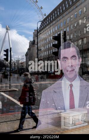 Die Figur, die als Mr. Bean bekannt ist, einer der erfolgreichsten TV-Comedy-Exporte Großbritanniens, blickt aus dem Fenster eines touristischen Schmuckhändlers in Waterloo, wo sich das London Eye noch während der dritten Sperre der Coronavirus-Pandemie am 11th. März 2021 in London, England, dreht. Stockfoto