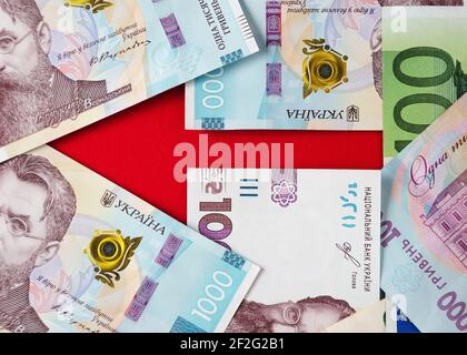 Ein Pfeil mit Banknoten der ukrainischen Griwnja und Euro gesäumt 5 Stockfoto