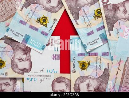 Ein Pfeil mit Banknoten der ukrainischen Griwnja und Euro gesäumt Stockfoto