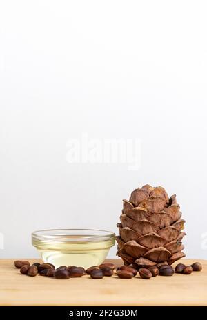 Banner, Bio-Kosmetikkonzept, Glasflasche mit Öl, Zeder auf hellem Holzhintergrund Stockfoto