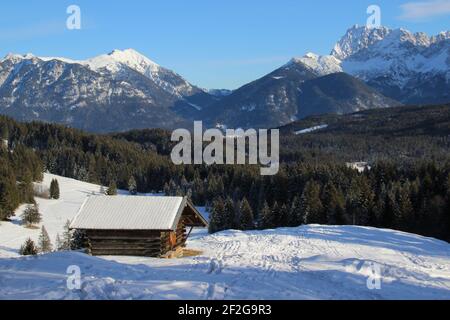 Winterwanderung bei Mittenwald, Elmau, Klais, Europa, Deutschland, Bayern, Oberbayern, Werdenfels, Winter, Heuscheune im Sonnenschein vor dem Karwendelgebirge Stockfoto