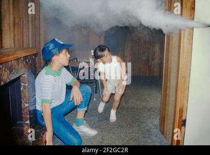 Zwei Mädchen sind in einem Anhänger, der sie 1990 in Manatee County, Florida, USA, über Brandschutz unterrichtet. Hier, in einem Haus-Mock-up, eine Demonstration bringt sie aus der Nähe, um die Gefahren von Rauch in einem Hausbrand zu erleben. Die mobile Ausstellung, gesponsert vom lokalen sicherheitsrat), könnte zu Schulen und öffentlichen Veranstaltungen in der gesamten Grafschaft gefahren werden. Dieses Bild ist von einer alten amerikanischen Amateur-Farbtransparenz. Stockfoto