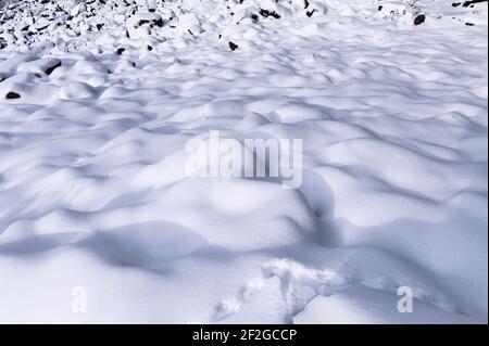 Flauschige weiße Schnee Haufen bedeckt Wellenmuster auf Hügel in Winter Stockfoto