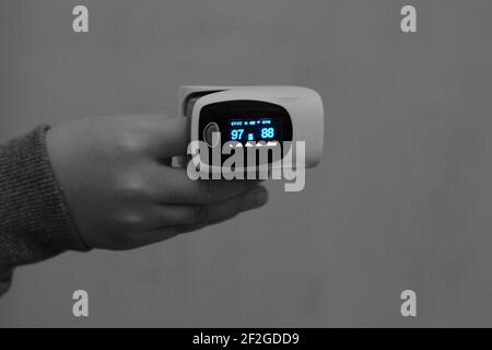 Pulsoximeter mit Fingerspitzen, die mit dem Zeigefinger von verbunden sind Ein Kind, das die Sauerstoffsättigung im Blut und in der Herzfrequenz misst Stockfoto