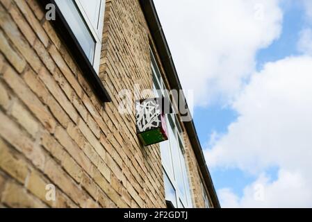 Ein kleines, braunes Vogelhaus aus Holz auf einem Gebäude Stockfoto