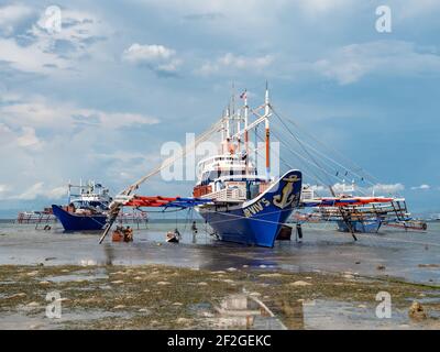 Wartungsarbeiten an einem traditionellen Fischerboot mit Stützen in Tinoto, einem Fischerdorf in Maasim, Provinz Sarangani auf den Philippinen Stockfoto