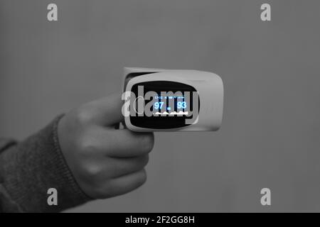 Pulsoximeter mit Fingerspitzen, die mit dem Zeigefinger von verbunden sind Ein Kind, das die Sauerstoffsättigung im Blut und in der Herzfrequenz misst Stockfoto