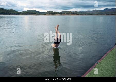 Junger Mann, der im Nationalpark in den See taucht Stockfoto