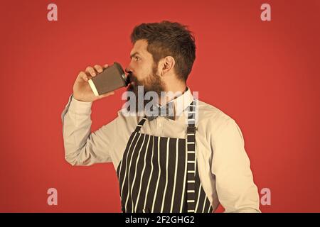 Mehr Kaffee. Ernst Barista trinken großen Latte. Professionelle Kellner oder Barkeeper servieren Kaffee. Brutal Kaffeemaschine. Porträt von bärtigen Barista stehen im Café. Barista gutaussehende Arbeiter. Stockfoto
