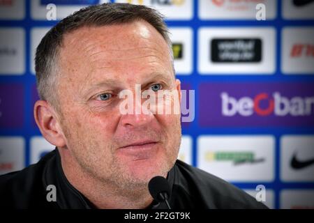 Genks Cheftrainer John van den Brom im Bild während einer Pressekonferenz des belgischen Fußballteams KRC Genk, Freitag, 12. März 2021 in Genk, über die se Stockfoto