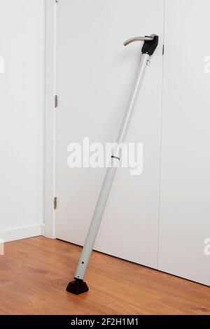 Ein Türblockierer Sicherheitsriegel in Gebrauch durch Verstärkung der Weiße Tür eines Hauses von innen Stockfoto