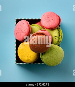 Bunte Macarons in einer Geschenkbox auf blauem Hintergrund Stockfoto
