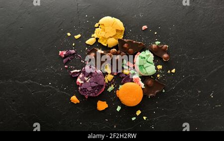 Krümel von süßen Macarons auf einem schwarzen Stein Tisch Stockfoto