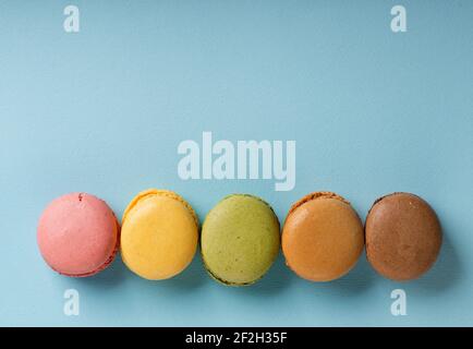 Süße Runde Macarons auf blauem Hintergrund Stockfoto