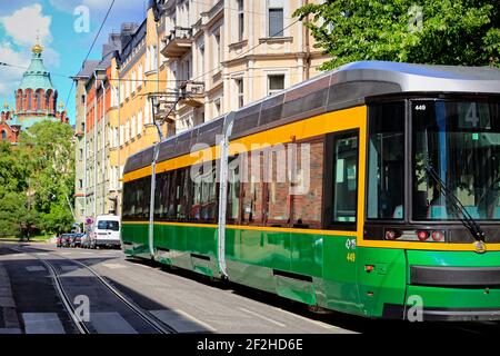 Grüne HSL Tram Nummer 4 an einem schönen Sommertag in einer engen Wohnstraße in Katajanokka, Helsinki, Finnland. Juli 4, 2019. Stockfoto