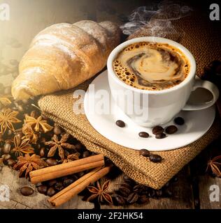 Morgenkaffee und Croissant mit Gewürzen auf Tisch Stockfoto