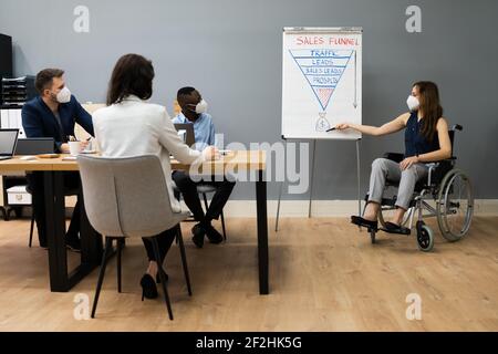 Behinderte Person, Die Präsentation Für Verschiedene Gruppe In Gesichtsmaske Stockfoto