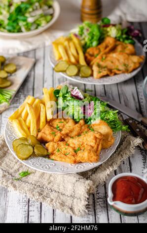 Zartes Schnitzel mit frischem Salat, Tomaten und pommes frites Stockfoto